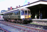 Green Class 122 DMU with yellow panel in station