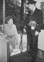 Boy gets on board railbus watched by guard